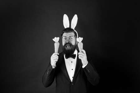 Handsome man wear bunny costume accessory. Celebration Easter holiday. Carrot is good for your...