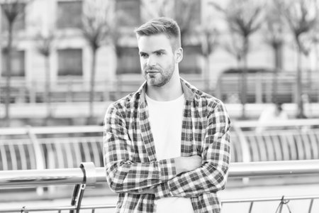 young unshaven man with trendy hair in checkered casual shirt outdoor, modern fashionの写真素材