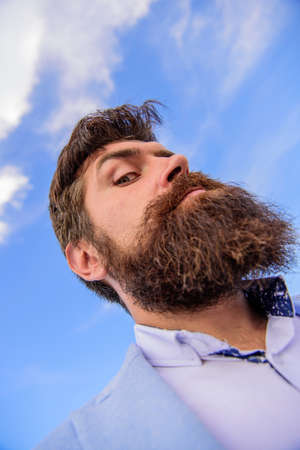 Expert tips for growing moustache. Man bearded hipster with mustache sky background. Check out my long beard. Ultimate moustache grooming guide. Hipster handsome bearded attractive guy bottom viewの写真素材