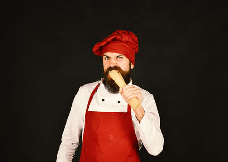 Man or bearded hipster eating raw pasta or macaroniの写真素材