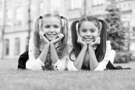 School friends formal clothes relaxing on green grass, successful future conceptの写真素材
