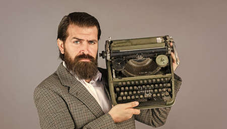 choosing retro. professional typist make notes typing. modern and old technology. digital business. successful businessman use retro typewriter. mature man hold vintage device. first draftの写真素材