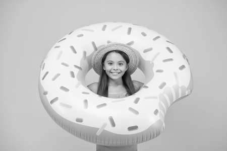 Girl with inflatable rubber ring at swimming pool. little girl going to play in water. having fun on the beach. happy kid on summer beach. Relaxing in the Sea. having fun in waterparkの写真素材