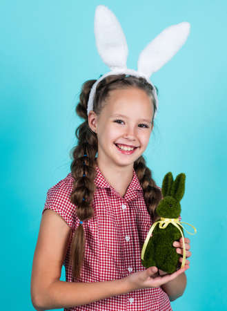 holiday is coming. happy girl holding easter hare toy. kid wear bunny ears. child in rabbit costume....