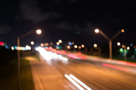 Watching transport moving in street. Urban traffic. Blurred car lights night. Urban night. Lights defocused background. Night city lights. Illumination and lighting. White and red blurred lampsの写真素材