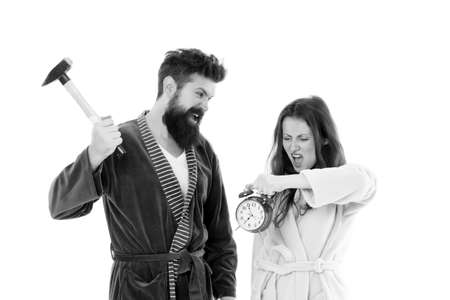 Its early time. Sleepy couple in love in morning time. Angry hipster and woman breaking alarm clock...