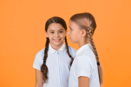 small girls in retro uniform. old school fashion. back to school. happy beauty with pigtails. happy childhood. brunette and blond hair. sisterhood concept. best friends. vintage style. Beauty salon.の写真素材