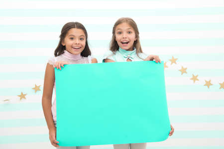 kids make advertisement. advertising your product. smiling little girls kids hold blue advertisement...