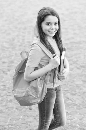 back to school. happy teen carry backpack. smiling kid hold book. childhood happiness. girl ready for lesson. get best education. Concept of knowledge day. modern school educationの写真素材