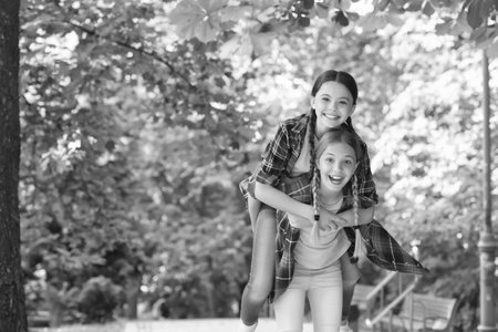this is our time. Positive models. Casual hipsters outfit. portrait of happy sisters. small kids girls in shirt. Two funny smiling hipster girls in trendy summer clothes. carefree kids posing outdoorの写真素材