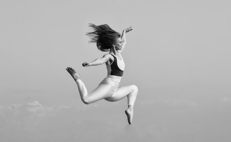 girl jumping high. sport in motion. full of energy. Attractive young sporty woman is working out in...
