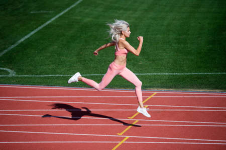 athletic lady compete in sprint. sport healthy lifestyle. fitness training outdoor. runner run fastの写真素材