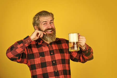 Bachelor day. Hipster drink beer. Mature bearded guy hold beer glass. Cheers toast. Holiday celebration. Taste your imaginations. Alcoholic. Thirsty man drinking beer in pub bar. Beer with foamの写真素材