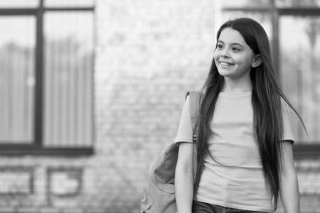 happy teen carry backpack. smiling kid in schoolyard. childhood happiness. girl ready for lesson. get best education. Concept of knowledge day. modern school education. back to school. copy spaceの写真素材