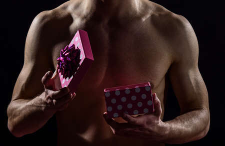 what is inside. love gift for date. passion and desire. man ready to erotic games. happy valentines day. sexual toys. lover naked body. be my valentine. protect yourself. sexy macho man with presentの写真素材