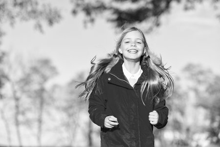 Full of life energy. Child cheerful on fall walk. Warm coat best choice for autumn. Autumn outfit concept. Kid girl wear coat for autumn season nature background. Keep body warm clothes autumn daysの写真素材