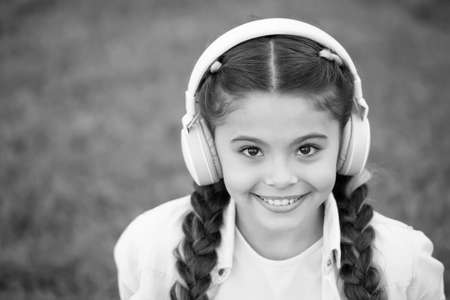 Casually beautiful. Happy childhood. Autumn snuggles. Autumn mood in headset for pretty girl. Happy little girl listen to music. Small child with happy smile. Feeling great. Just having funの写真素材