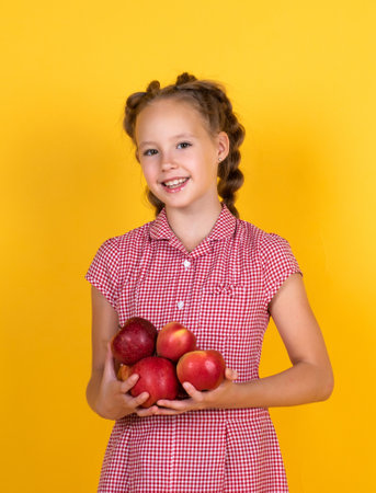 Spring style. happy girl holding apples from garden. kid hold fresh fruit. child eating red apple. summer healthy food. vegetarian dieting. fruits at fall harvest. Healthy nutrition in autumnの写真素材