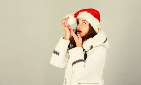 Waiting frosty christmas days. Emotional woman makeup face. Santa girl. Girl wear white jacket and santa hat. Jacket has extra insulation to protect your body from sharp winter weather. White jacketの写真素材