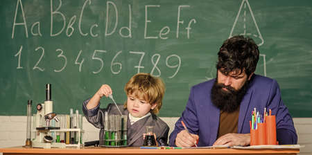 small boy with teacher man. Formula. experiments in organic chemistry laboratory. son and father at school. Wisdom. Back to school. biotechnology research. Education originates from inside.の写真素材