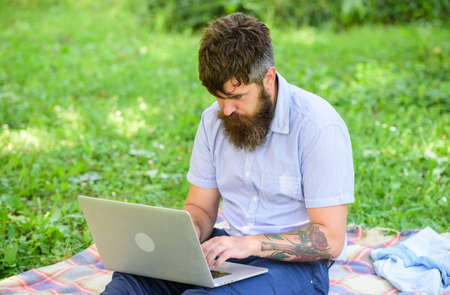Writer looking for inspiration nature environment. Inspiration for blogging. Looking for inspiration. Man bearded with laptop sit meadow nature background. Blogger becoming inspired by natureの写真素材