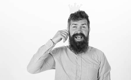 Party king, birthday concept. Happy bearded man on white background. Man with long beard and open mouth holding paper crown. Hipster with excited look and trendy beard posing with paper accessoriesの写真素材