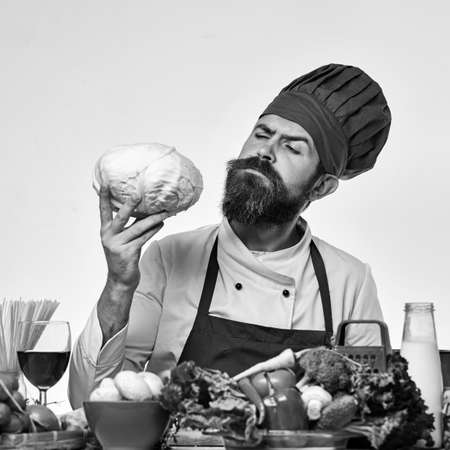Chef prepares meal. Cook with curious face in burgundy uniformの写真素材