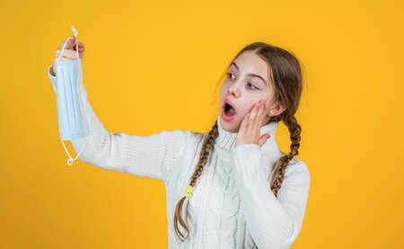 oh my god. safety protective items during coronavirus pandemic outbreak. symptom of covid 19. girl need igg immunity test. virus pneumonia. surprised patient child wearing respirator maskの写真素材