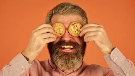 Obsessed with pastry. Happy hipster eat cookie dessert. Sweet cookies. Sweet Tooth concept. Cookies on his mind. Bearded man hold cookies on eyes. Yummy delicious treats. Recipe homemade cookiesの写真素材