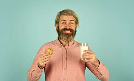 The concept of healthy eating. Organic farm products for Breakfast or lunch. milk and cookies. happy farmer eat cookie dessert. bearded man drink useful milk with pastryの写真素材