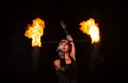 Burning desire. Sensual woman twirl flaming baton in darkness. Fire performance. Art show. Baton twirling. Holiday celebration. Night party. Desire and passionの写真素材