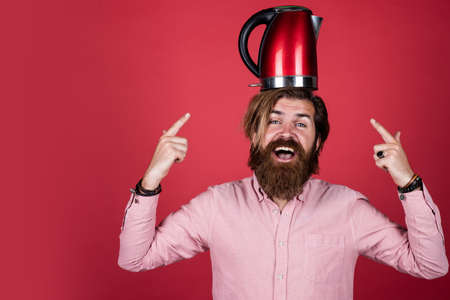 brutal caucasian hipster with beard in shirt hold electric kettle, odern life