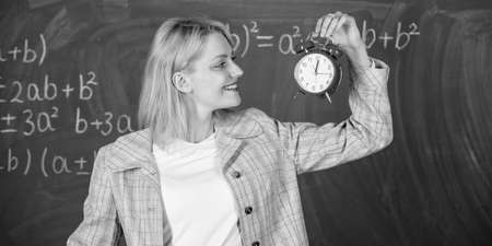 Always on time. Woman teacher hold alarm clock. She cares about discipline. Time to study. Welcome teacher school year. Looking committed teacher complement qualified workforce educatorsの写真素材