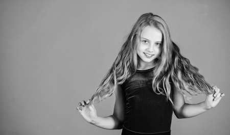 Ballroom latin dance hairstyles. Kid girl with long hair wear dress on violet background. Hairstyle for dancer. How to make tidy hairstyle for kid. Things you need know about ballroom dance hairstyleの写真素材