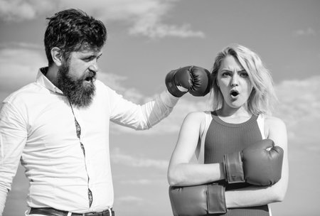 Couple in love boxing gloves sky background. Man punch girl boxing glove. She did not expect be attacked. Prepare for sudden attack. Woman undergoes violence. Stop violence. Learn to resist punchの写真素材