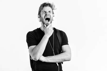 sleepy man. Enjoying music. new technology in modern life. sexy muscular man listen music. man listen new song isolated on white. unshaven man in blue tooth technology earphones. moder life conceptの写真素材