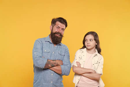 Loving their casual look. Small child and bearded man in casual style. Father and little daughter yellow background. Casual fashion. Casual appeal. Family clothing store. Fashion and styleの写真素材
