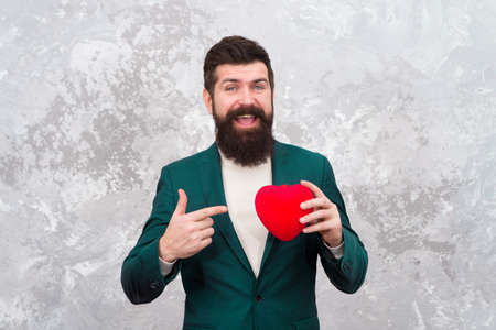 Give your heart for Valentines day. Organ donation. Bearded man point finger at red heart. Heart problem or attack. Heartache. Chest pain. Health and care. Healthcare. Have heart, donate lifeの写真素材