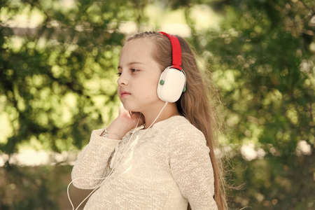 Cute little girl enjoying music using headphonesの写真素材