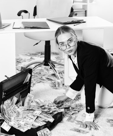 Woman counting money. Business investment. Office is littered with money. Business challenges. Owner...