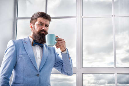 But first coffee. Man groom drinking coffee early in morning. Beginning of great day. Important day in his life. Get ready. Enjoy every minute. Hipster in tuxedo with bow tie making sip of coffeeの写真素材