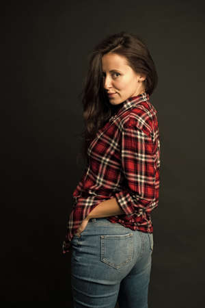 Simple casual clothes. Feeling comfortable. She prefers casual style. Country style. Woman checkered shirt. Attractive confident girl black background. Sexy people. Casual fashion. Fashionable outfitの写真素材