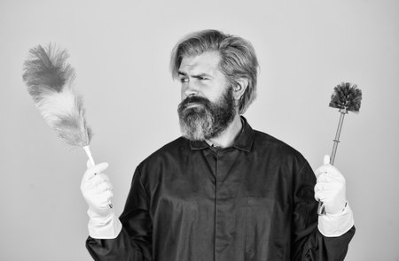 Cleaning apartment. Hipster hold cleaning tool. Cleaning concept. Man use pp duster. Dust allergy. Husband cleaning home. Small duster. Cleaning service. Housekeeping duties. Professional cleanerの写真素材