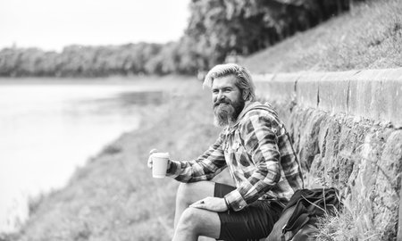 mature traveler having rest. take away coffee. good morning inspiration. brutal man with beard drinking tea from cup. bearded man drink coffee outdoor. hipster relax in park. copy spaceの写真素材
