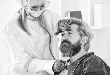 Diagnosis of pneumonia. Sars concept. Doctor protective equipment examines male patient suspected virus infection. Virulent infectious disease caused by virus.  symptomsの写真素材