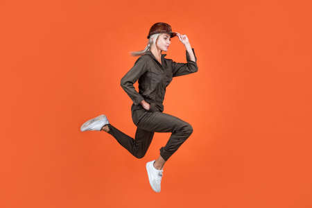 jumping woman in working uniform and hard hat running hurry up on work, quality service