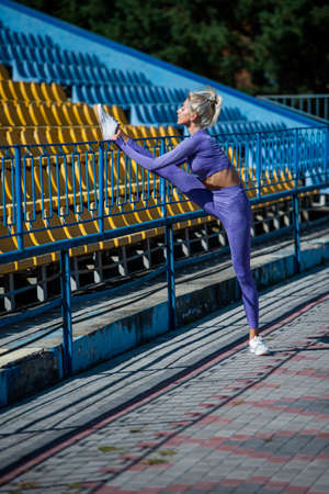 sexy fitness woman stretching in sportswear on stadium, stretchの写真素材