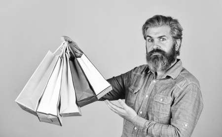 Retail concept. Happy holidays. Handsome buyer. Free shipping. Bearded man hold shopping bags. Seasonal sale. Hipster buying sale price. Black Friday. Cyber monday sale. Boost sales. Profitable dealsの写真素材