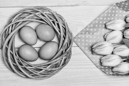 Spring vibes. Easter is coming. Colorful bright eggs and bouquet fresh tulip flowers on yellow background top view. Spring holiday. Tradition celebrate easter. Happy easter season. Easter eggs symbolの写真素材