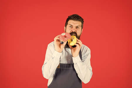 Hipster bearded baker eat donuts. Doughnut bakery. Bearded cheerful well groomed man selling donuts. Carbs and calories. Bakery owner. Bakery business. Baked goods. Sweets and cakes. Junk foodの写真素材